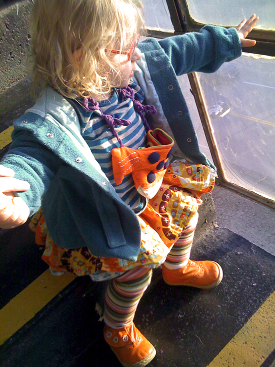 Toddler Girl on warehouse steps looking out window
